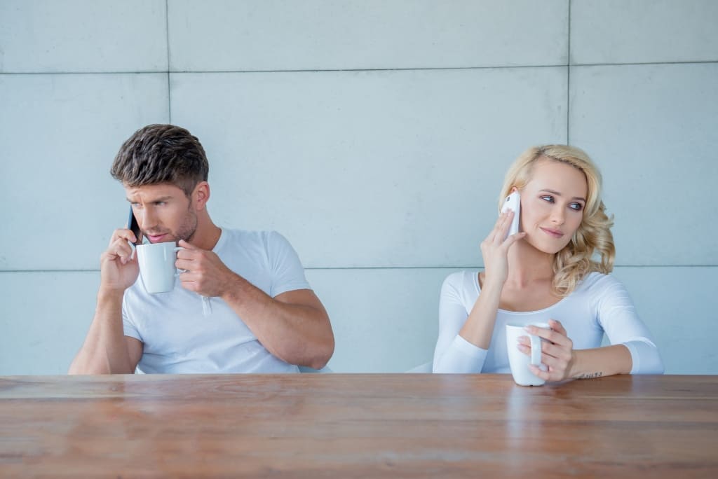 Couple Drinking Coffee And Talking On Phone